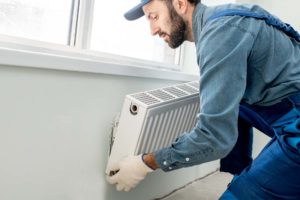 plumber placing radiator on wall