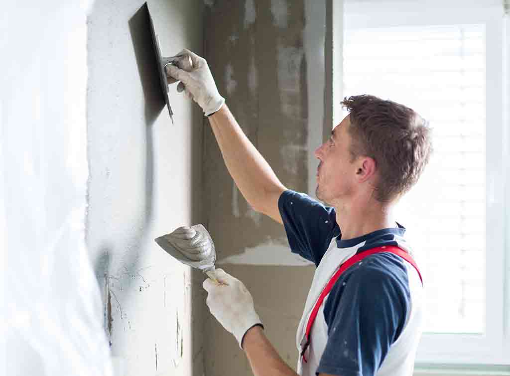Plasterer skimming a wall