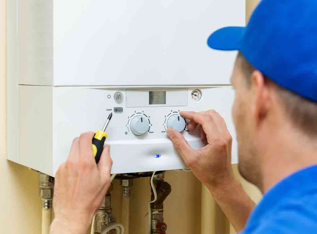 gas central heating engineer working on a boiler