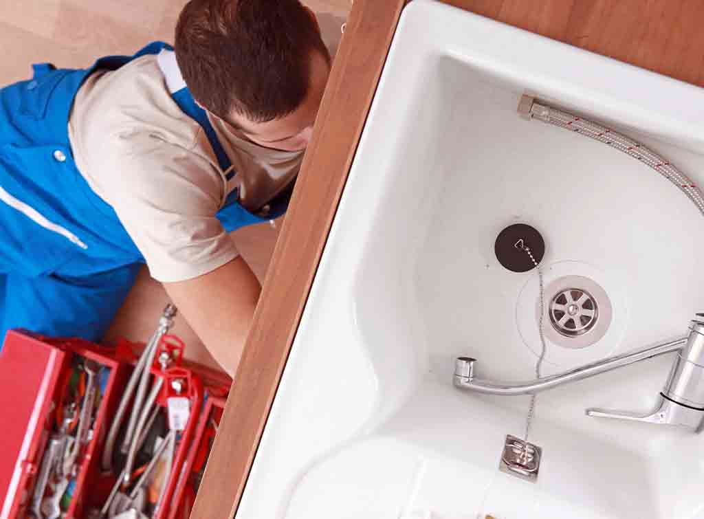 A plumber installing a basin