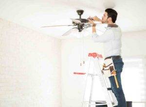 Electrician installing a ceiling fan