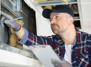 Tradesperson removing cavity wall insulation