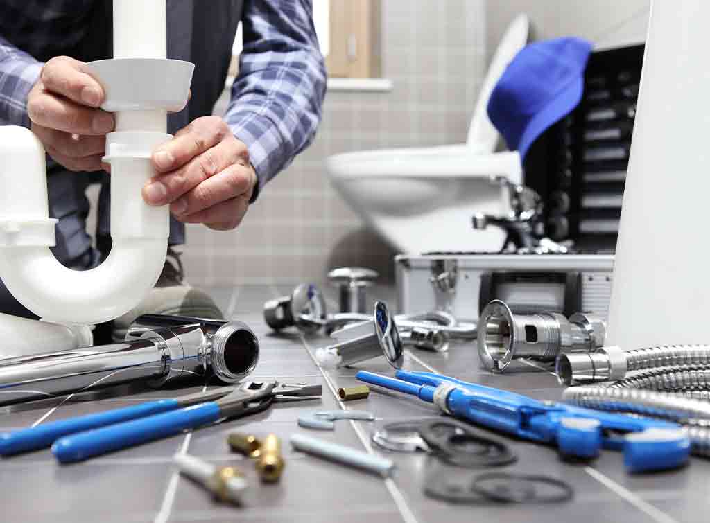 Plumber repairing toilet syphon