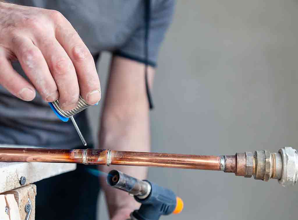Plumber soldering copper pipe