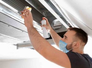 tradesperson cleaning an air vent