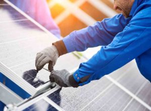 tradesperson maintaining a solar panel