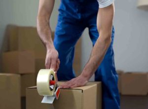 Checkatrade a man packing a box and closing it with tape