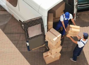 Checkatrade two men lifting a box from a van, surrounded by other boxes