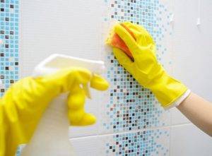 Tiles being scrubbed with sponge and bleach
