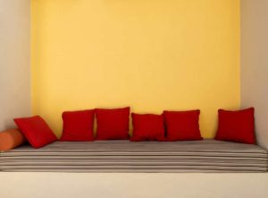 Modern seating in an alcove with a yellow wall