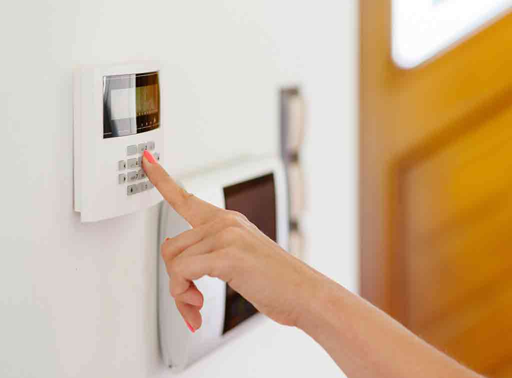woman pressing home alarm button
