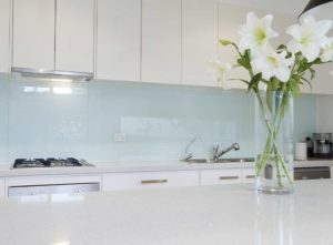 Glass kitchen splashback over a light blue wall - inexpensive kitchen splashback ideas