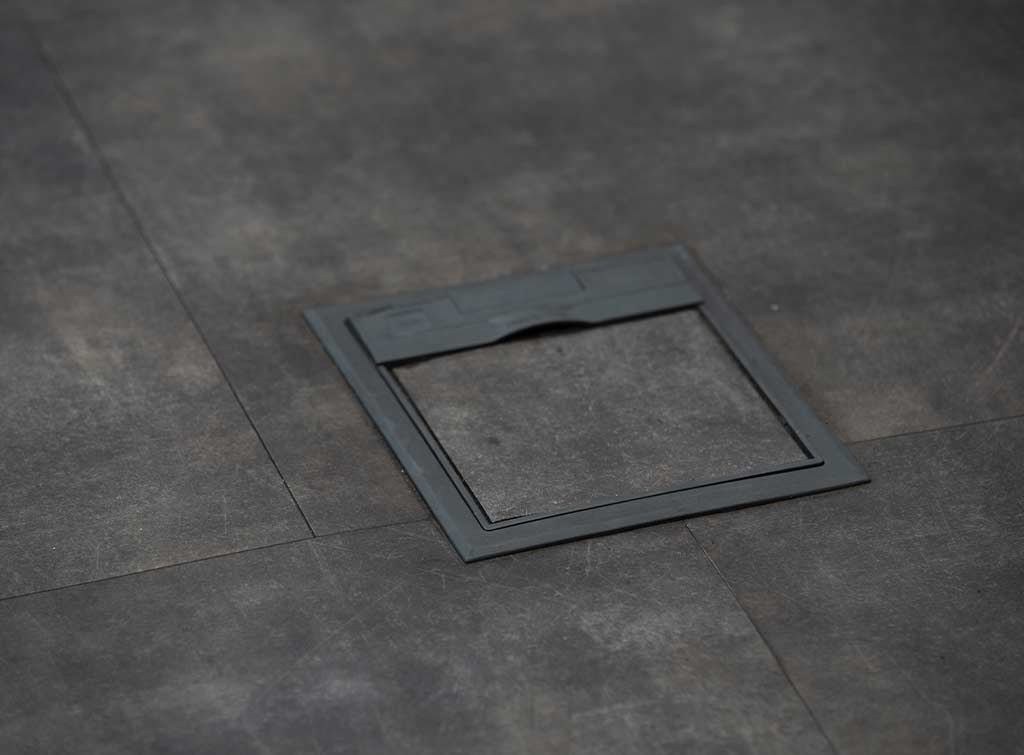 Cheap kitchen floor makeovers using viinyl - A square piece of grey vinyl taped on matching floor