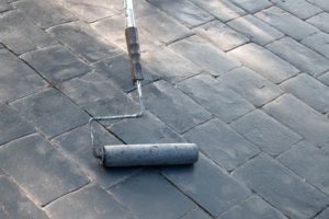 Freshly laid concrete with a stone pattern on it and the pattern roller in the picture - cost of concrete resurfacing - Cost of concrete resurfacing