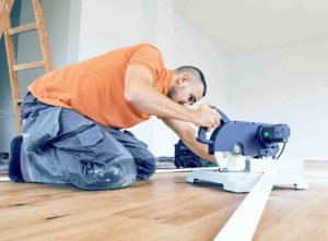 How to cut skirting board blog: Tradesperson on floor preparing the skirting board