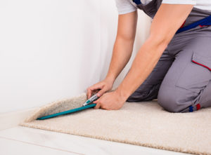 Carpet installer trimming cream carpet