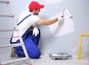 Professional painter and decorator painting wall