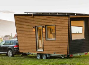 A car towing a tiny house - cost to build a micro home