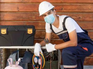 An air conditioner repair technician refilling Freon in a unit - Freon recharge cost