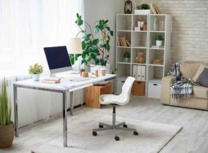 A bright white home office with a rug under the chair and desk - home office makeover with supportive flooring