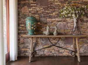 An inexpensive stone feature wall idea with a table in front of it