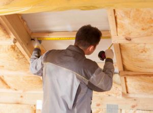 Man insulating a house to make it more energy efficient