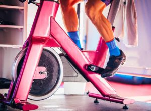 Peloton bike in bedroom. Bright pink bike for a fun aesthetic.