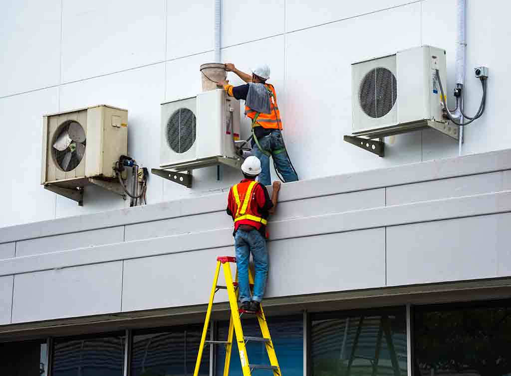 Engineers installing commercial air conditioning