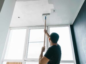 Decorator painting a ceiling