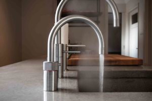 A tap in the kitchen with water running - cost of legionella risk assessment