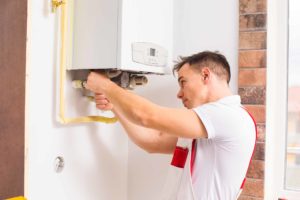 heating engineer looking at boiler