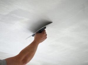Plasterer plastering a ceiling