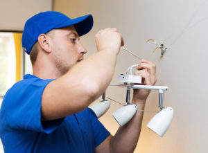 Qualified electrician installing a wall light
