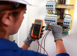 Female electrician checking a fusebox