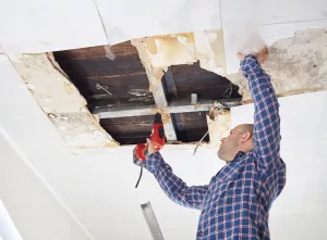Tradesperson fixing severe ceiling damage