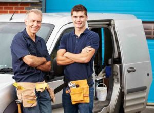 Two plumbers standing by their van