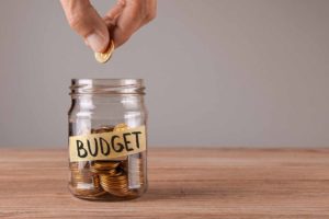 How to budget for a home renovation. Image: Budget jar with coins.