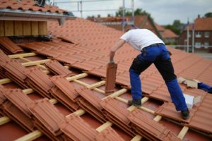Roofer laying roof tiles