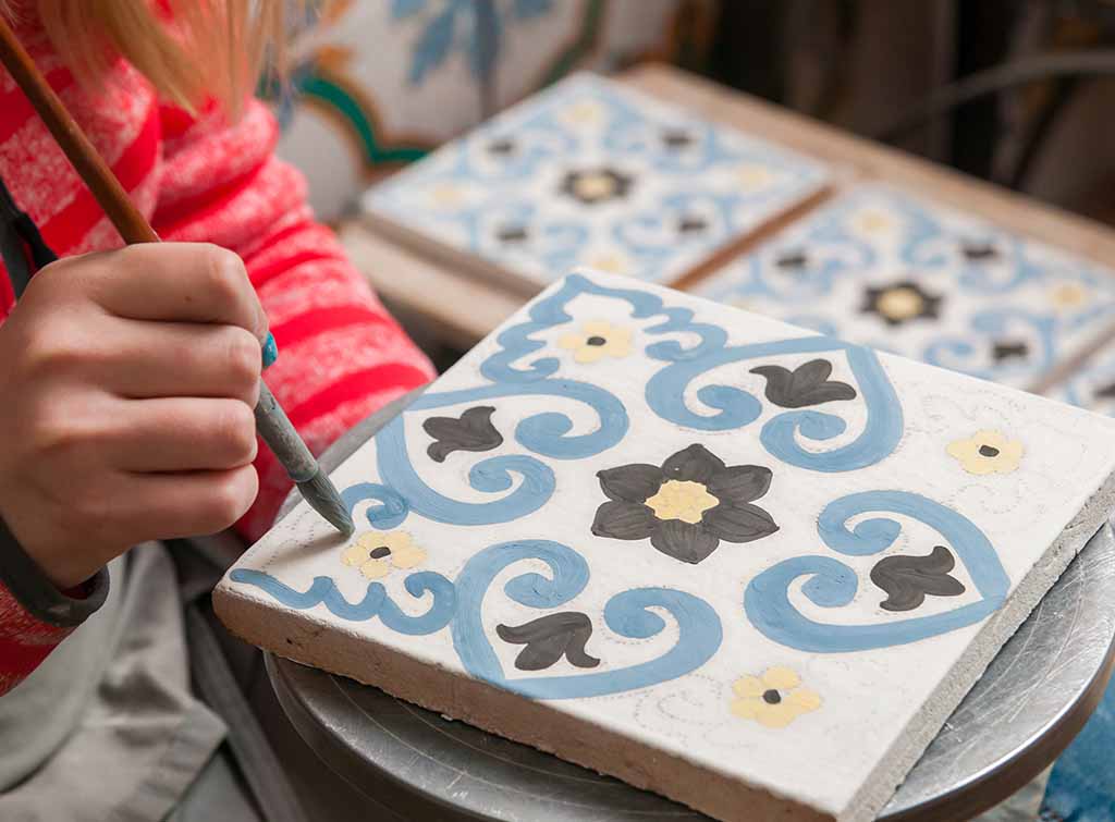 child painting tiles
