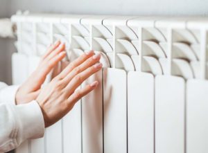 Hands being warmed against an electric heater