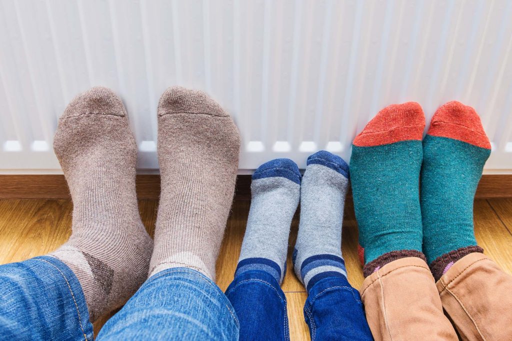 Feet in socks against a warm radiator