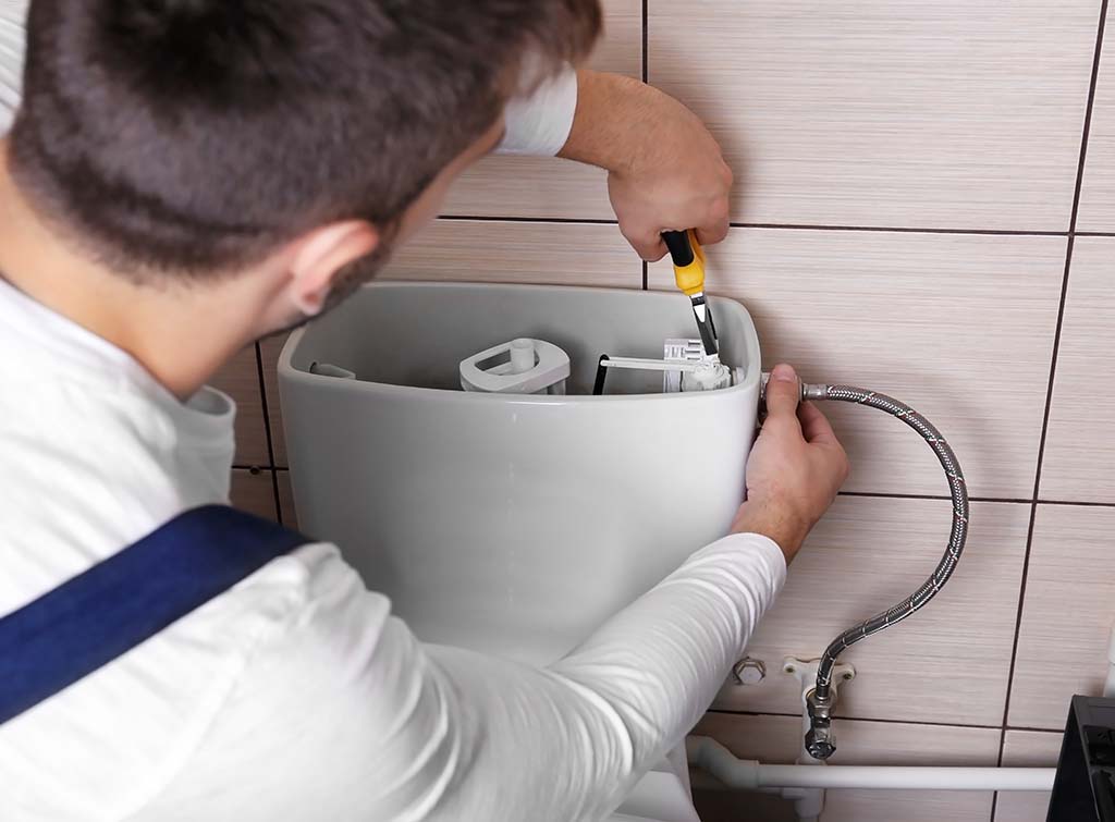 plumber fixing a toilet that won't flush properly