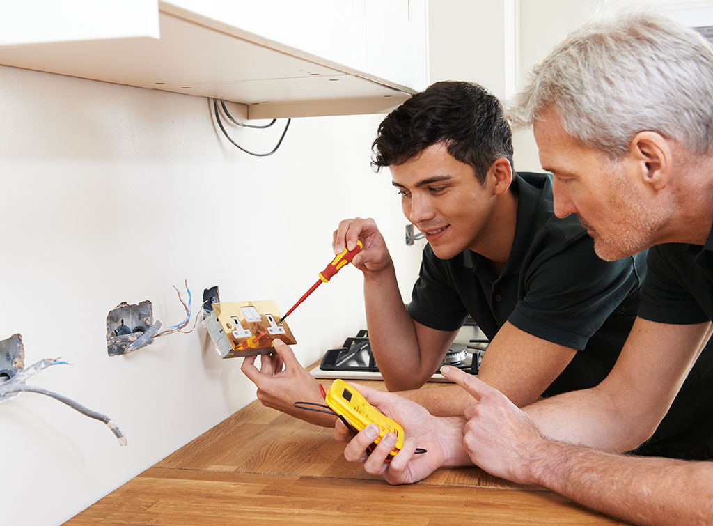 An electrical apprentice with his employer
