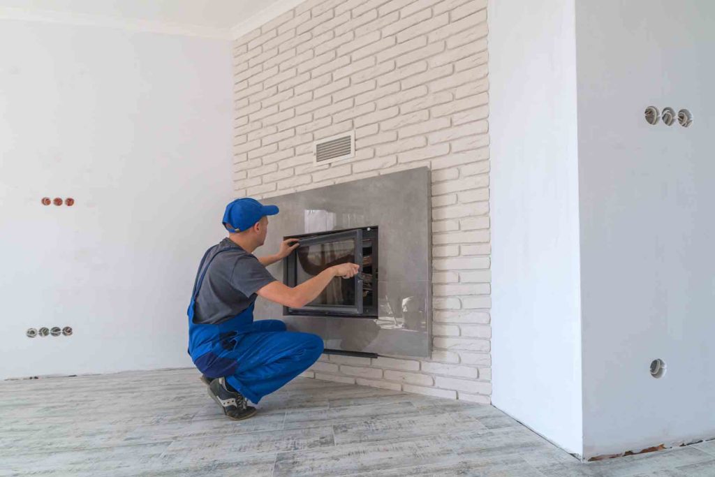 Gas engineer working on a gas fire inside a home