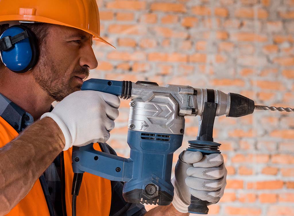 A builder using a hammer drill