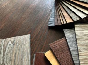 Various flooring planks fanned out in a row for Checkatrade's cost of vinyl flooring vs tile blog
