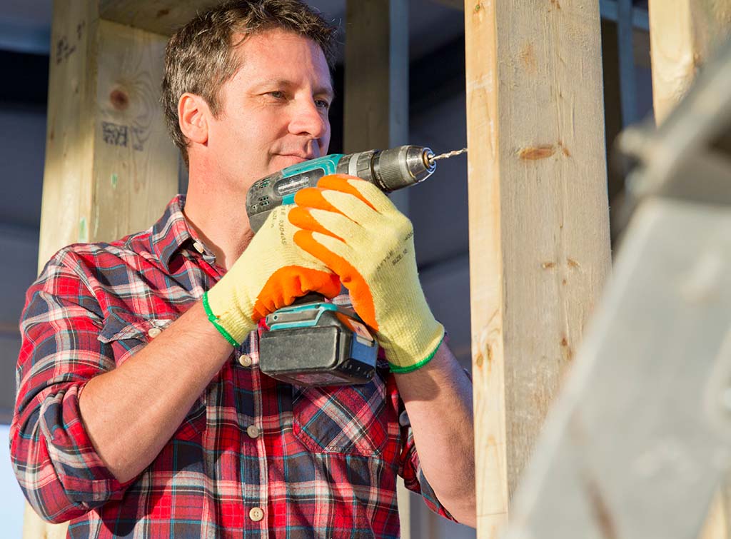 electrician using a cordless combi drill on-site