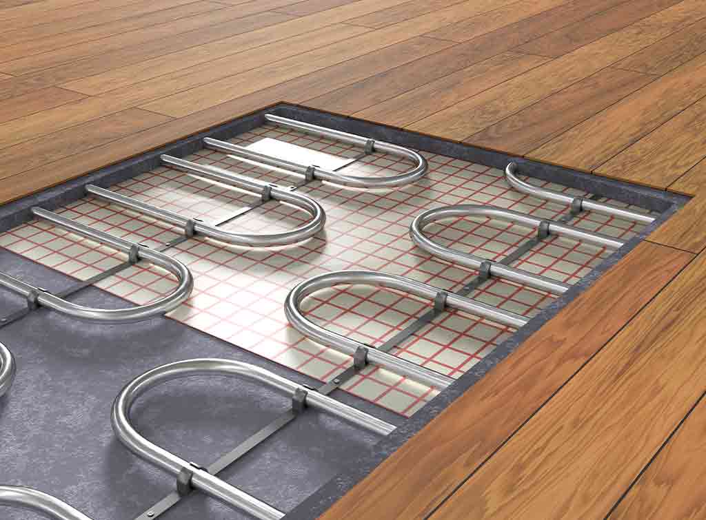 Image of section of underfloor heating next to wooden laminate floor for the blog: Is underfloor heating economical?