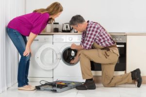 Checkatrade blog on 'how to fix a washing machine leak' - tradesperson fixing the drum