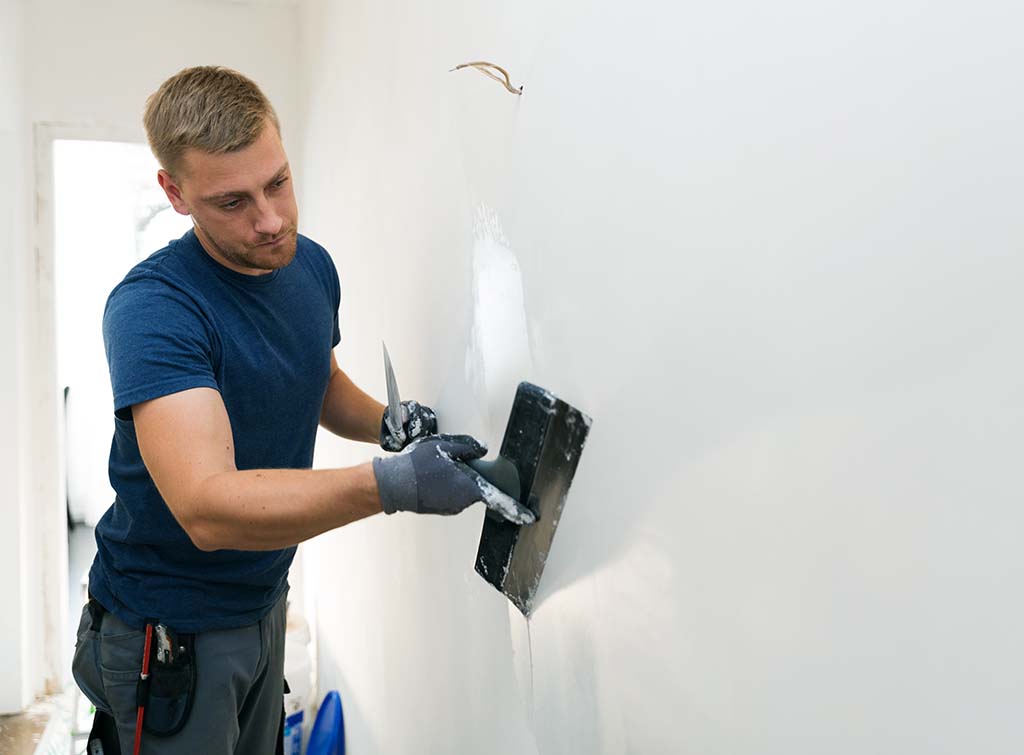 Plasterer finishing a wall